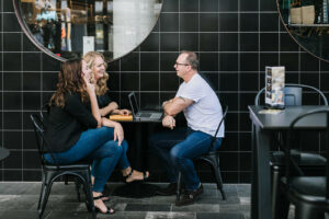 Three adults sitting at a café